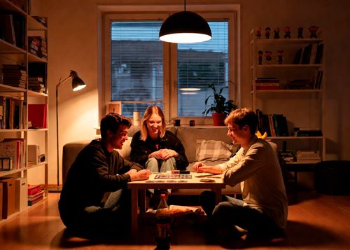 Трое друзей играют в настольную игру на полу